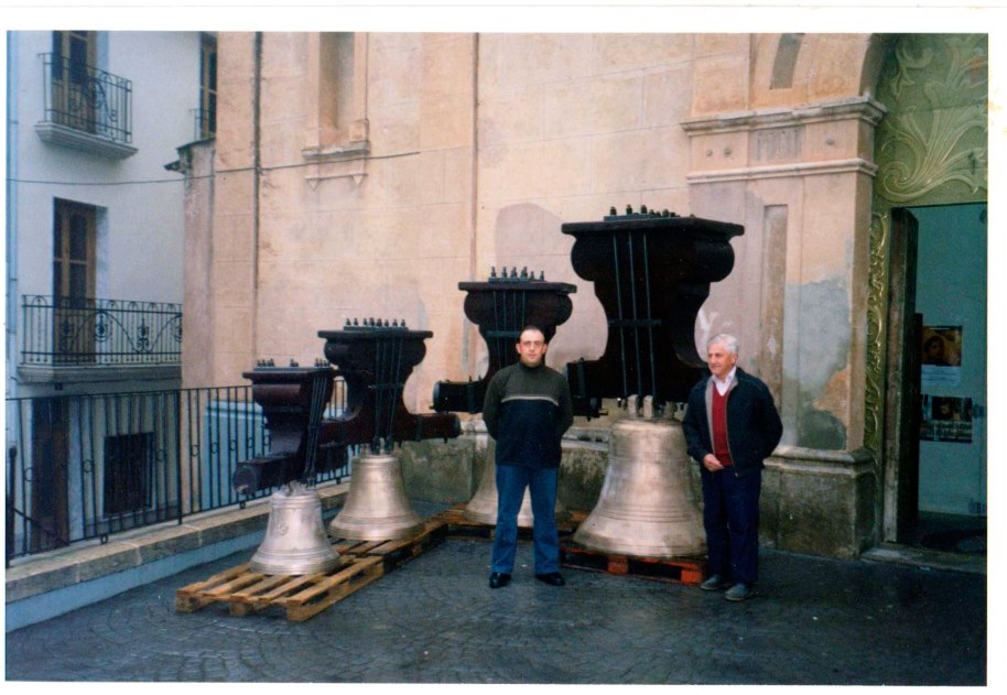 José 'Filiberto', pare i fill, davant de les quatre campanes, que acabaven de retornar al poble després de ser restaurades. Entre altres coses es va canviar els jous de ferro per altres de fusta, semblants als originals. La foto està datada el 31 de març de 2003.