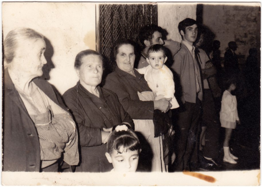 Dones i xiquets observant el pas d'alguna processó.