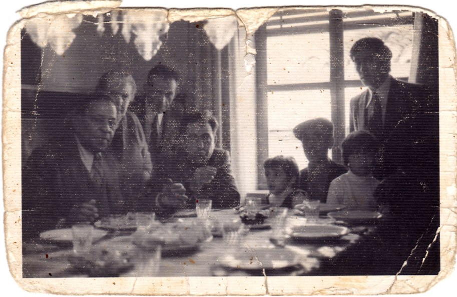 Una altra instantània de la família dinant amb Machín. La foto està molt gastadeta, possiblement perquè ha sigut molt toquejada i molt ensenyada.