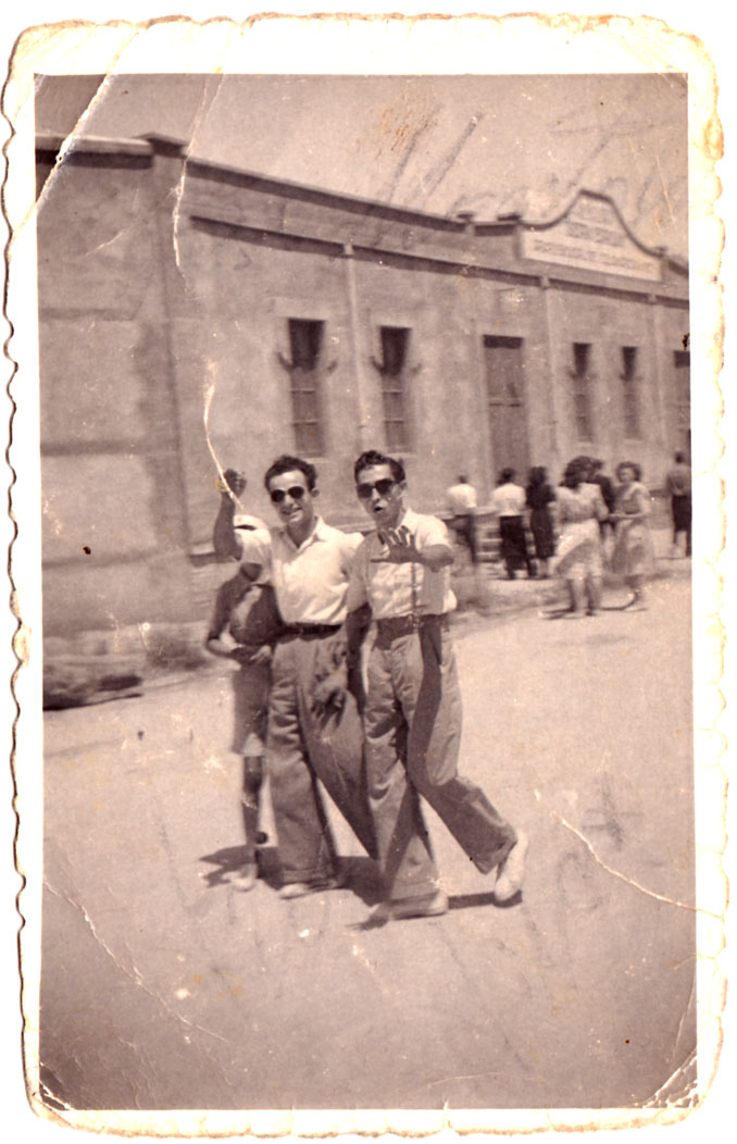 Dos galans passejant per la carretera al migdia d'un diumenge o festiu.