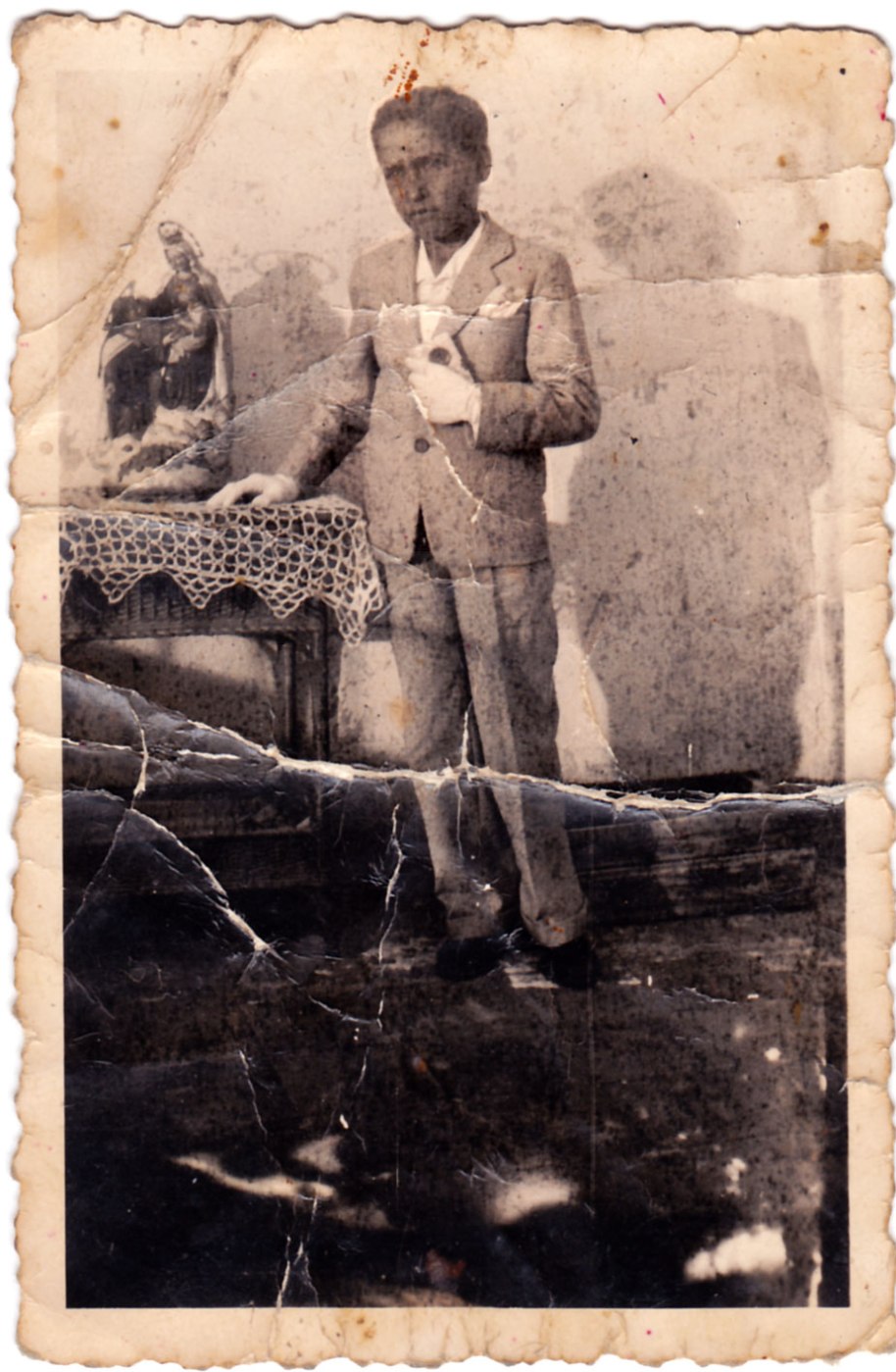 Una imatge atípica d'un xiquet de comunió. Està feta amb llum natural i en un decorat poc sofisticat. El tratge és molt normal, només els guants i el missalet donen idea del motiu de la foto. 