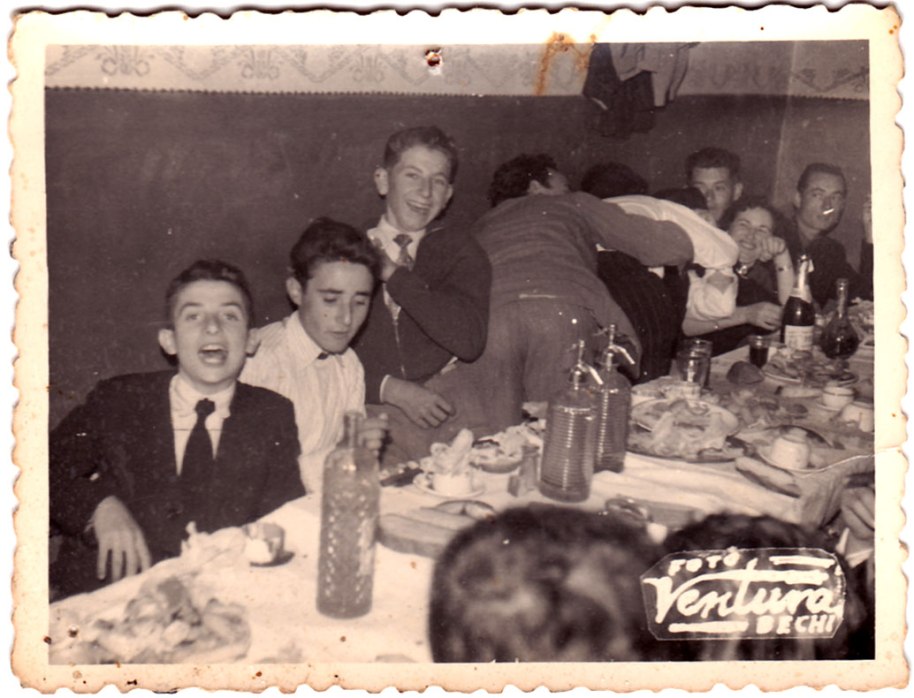 Pareix ser una boda. La data del segell posterior està difícil de llegir: podria ser el 21 de novembre de 1958 ó 59. Són, des de l'esquerra: Benjamín de Cabedo, Juanito Calo i José Juano. A l'altra punta pareix que es reconega a Vicente Pallarés, "Gilet". Els convits de les bodes es solien fer en les cases cases particulars. En la imatge es pot veure l'elegant cenefa que feien els pintors a meitat de la paret, amb ajuda de trepes i una tècnica a basse de cola de conill