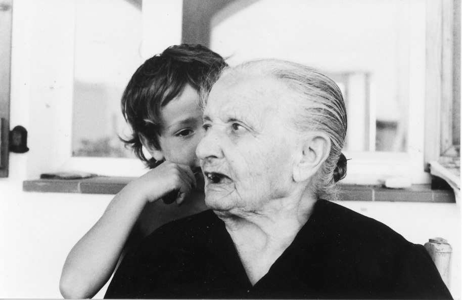 La ti Teresa 'Mateua' amb el seu net Guillem, estiu de 1984. Foto Paco Monsonis. La seua neta Pili Blasco ens ha fet arribar aquest text: Teresa Bainat - (1893 – 1990). Mor sa mare quan encara és una xiqueta i s’ha d’encarregar dels germanets més menuts. La seua serà una joventut dura, com la de tantes famílies humils. Es casa molt joveneta amb Enrique Vilar, viudo, molt més major que ella. Té set fils. Quatre moren molt menuts; José mor pels 20 anys, de malaltia, i Enrique a la guerra. L’únic que li quedarà es Juan (1921 – 2002). Quan Juan i la dona, Rosario, se’n van a França a treballar en 1957, (com ho va fer més d’un milió d’espanyols, en l’onada migratòria dels anys 60), deixen les dos xiquetes en Artana amb Teresa i Pascuala, la germana. Elles se n'ocuparan quasi dos anys. Teresa va estar vivint a París durant un temps, però enyorava tant el seu poble que al cap d’un any se’n tornà a casa. Molt de temps després, els veïns francesos encara se’n recordaven d’aquella dona alegre i comunicativa que es baixava una cadira i s'assentava al carrer quan feia bon temps, com solia fer a Artana… Va passar mitja vida esperant cada estiu, quan tornaven el seus de França… Però sempre la vam veure plena d'il•lusió i ganes de viure. Era una dona forta, positiva, sempre mirant cap endavant.
